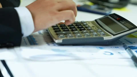 Person Using Calculator on Financial Documents, Close-up of a person using .. Stock Footage 321223714