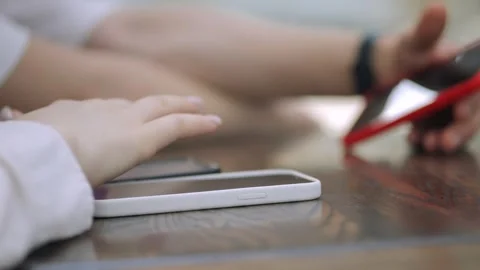 Person is using a cell phone while another person looks on Stock Footage 311395648