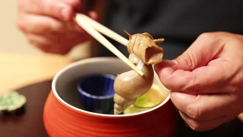 Person Using Chopsticks to Extract Sea Snail Meat from Shell Stock Footage 335118451
