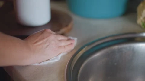 Person using cloth to wipe kitchen counter and sink thoroughly. Adult individual Stock Footage 346401114