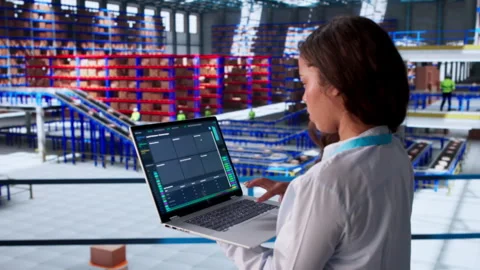 Person Using Computer To Check Warehouse Inventory Stock Footage 336796402