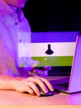 Person using computer with holographic lab flask icon overlay Stock Photos