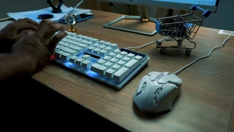 Person using a computer keyboard with a small shopping cart on the desk Stock Footage 315981206