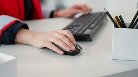 Person using computer mouse and typing on keyboard Stock Photos
