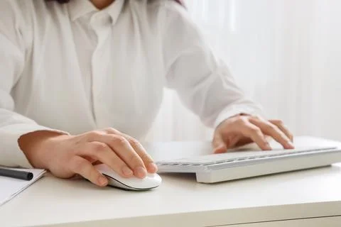 Person using computer mouse and keyboard at desk Stock Photos