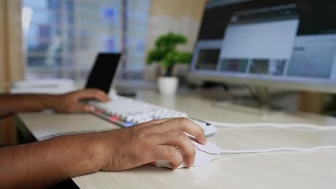 Person using a computer mouse at a desk with a keyboard and monitor Stock Footage 320724093