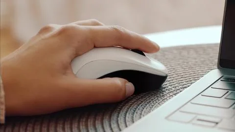 Person using computer mouse on a desk with laptop 写真素材
