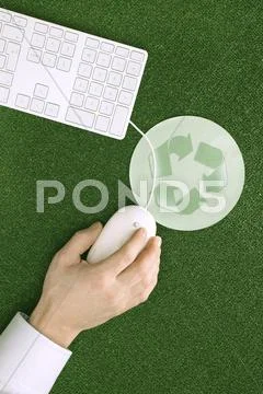 Person using computer mouse, mouse pad with recycling symbol, elevated view Stock Photos