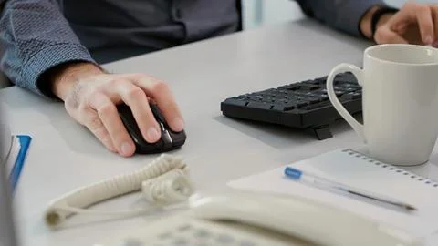 Person using computer mouse at office desk Stock Photos