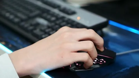 A person using a computer mouse, a person playing a game on a desktop compute Stock Footage 166322503