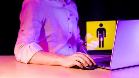 Person using computer mouse with warning sign overlay in neon light Stock Photos