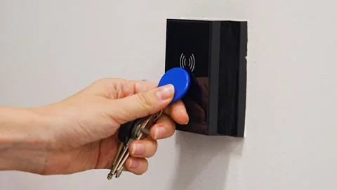Person using contactless key fob on indoor access control reader. Secure Stock Footage 346397250