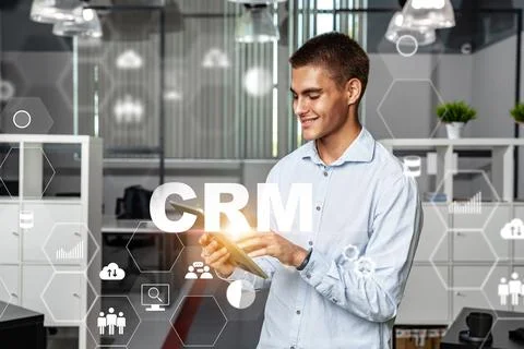 Person using CRM app in modern office during daytime with digital elements .. Stock Photos