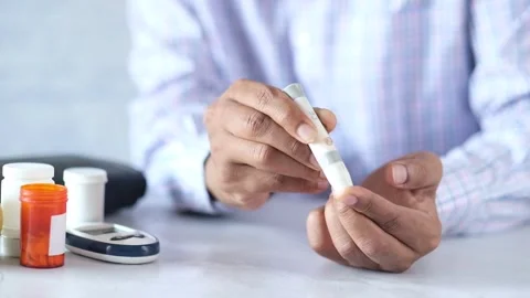 Person using diabetic lancing device to test blood glucose level at home du.. Stock Footage 332408698