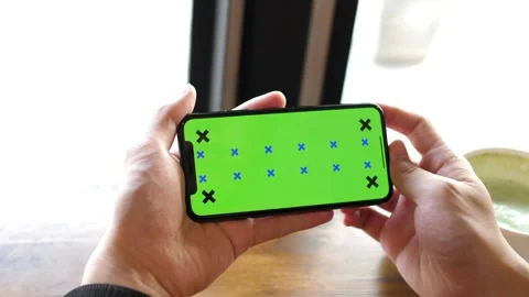 Person Using Digital Smart Phone in Landscape Mode Green Screen Background, Video stock 336585736