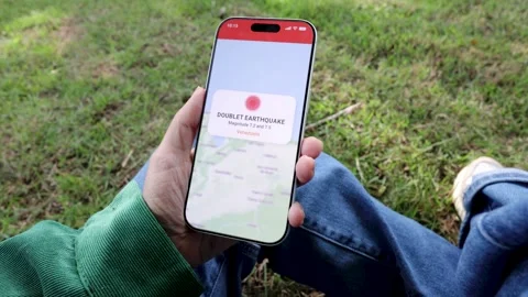 Person using earthquake app on mobile phone for real-time emergency alert - High Video stock 339039852