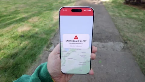 Person using earthquake app on mobile phone for real-time emergency alert - High Видео 339039853