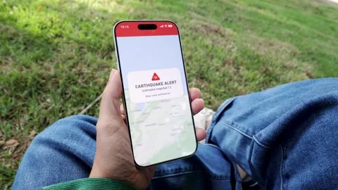 Person using earthquake app on mobile phone for real-time emergency alert - High Stock-Footage 339506473