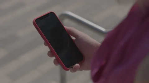 Person using finger to touch phone screen on sidewalk Stock Footage 134582969