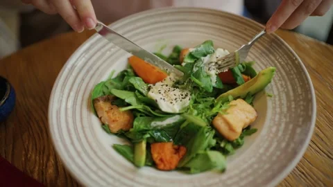 Person using fork and knife to eat healthy salmon salad with avocado and sw.. Vídeos de archivo 339783692