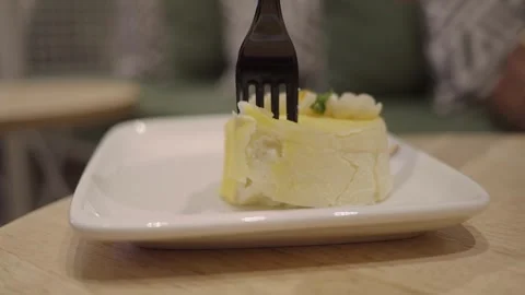 Person Using Fork to Eat Small Yellow Cake Stock Footage 345696872
