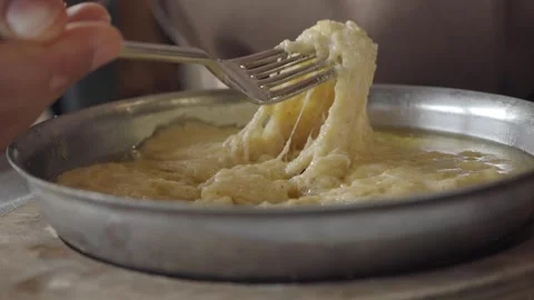 Person Using Fork to Lift Melted Cheese from Metal Pan Vidéo 338218065