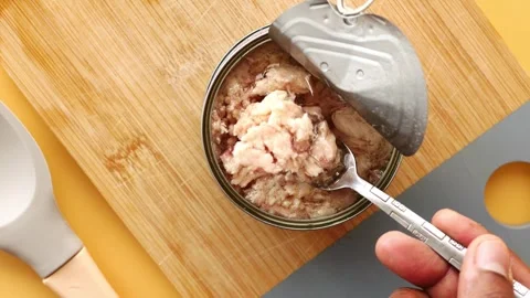 Person using fork to shred canned tuna fish for preparation of a meal on a .. Stock Footage 332745564