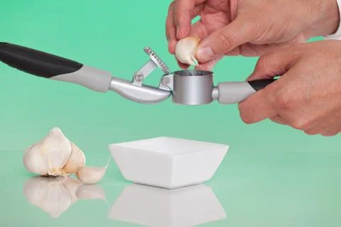 Person using a garlic press Stock Photos