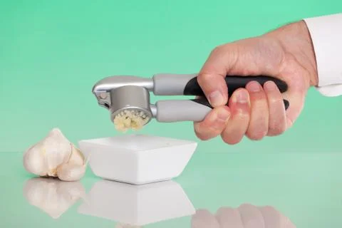 Person using a garlic press Stock Photos