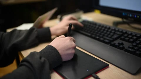 Person using graphic tablet connected to computer for digital design work Stock Footage 332620641