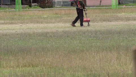 Person Using Grass Trimmer in Field Stock Footage 312781871