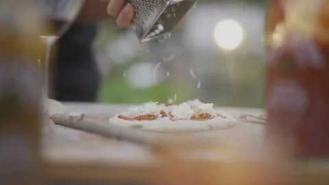 A person is using a grater to grate cheese onto a plate of food Video stock 297843158