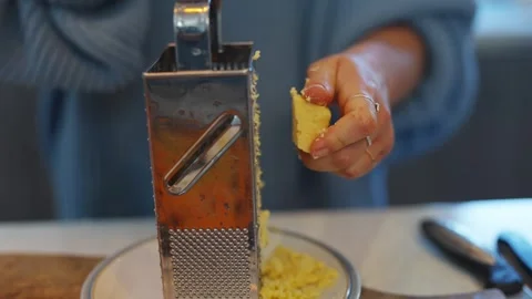 A person is using a grater to grate some food Stock Footage 295368880
