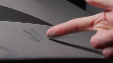 Person Using Index Finger to Wipe Dust Off a Dirty Dark Grey Textured Surface Vídeos de archivo 335634716