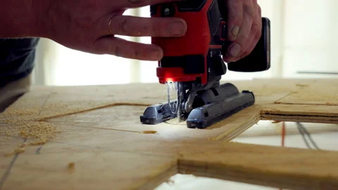 Person using the jigsaw power tool. Worker is holding jigsaw with the both hands Stock-Footage 310633298