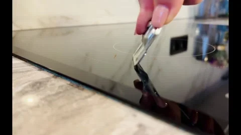 A person is using a knife to cut a piece of paper on a stove 스톡 동영상 274260711