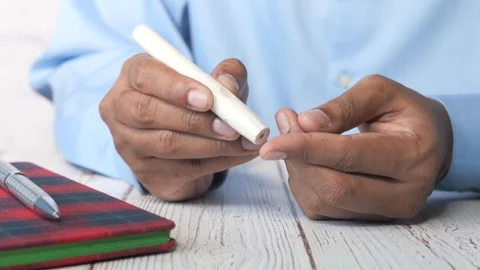 Person using lancet device for blood sugar test, diabetes monitoring footage. Stock Footage 332744629