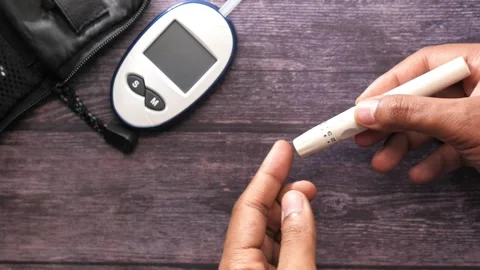 Person using lancing device on finger for blood glucose test with glucomete.. Stock Footage 333031628