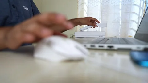 Person using a laptop and mouse on a desk, blurred background Stock Footage 317736770