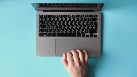 Person Using Laptop on Blue Background Stock Footage 325036272