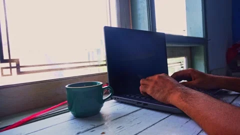 A Person Using A Laptop Computer And Drinking Coffee While Working At A Des.. Stock Footage 345139517
