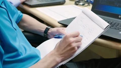 A person using a laptop computer sitting on top of a table Stock Footage 155535814