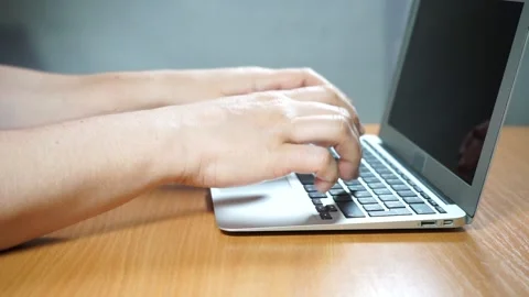 A person using a laptop computer sitting on top of a table Video stock 156723341