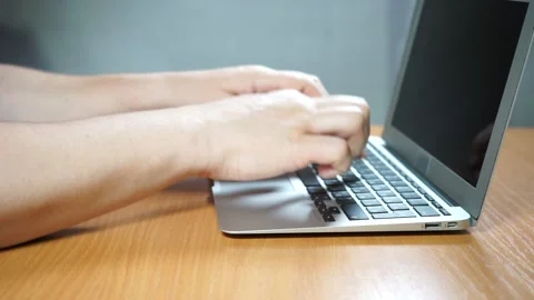 A person using a laptop computer sitting on top of a table Video stock 156723363