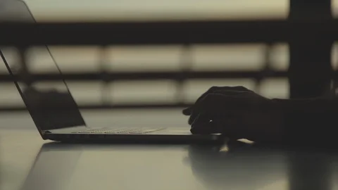 Person Using Laptop at Dusk 動画素材 98198493