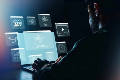Person using a laptop for e-learning with online resources in a dark Stock Photos