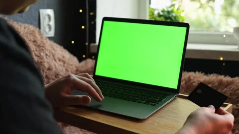 Person using laptop with green screen and credit card for online shopping Stock Footage 340264787