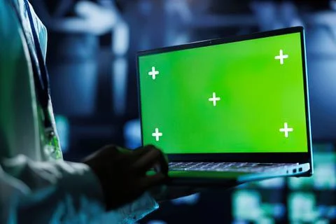 Person using laptop with green screen and plus signs Stock Photos