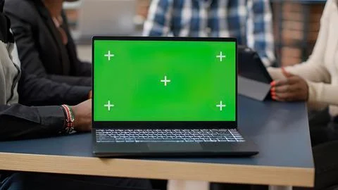Person using laptop with green screen plus signs Stock Photos