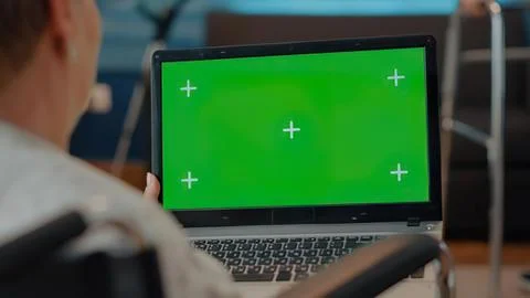Person using laptop with green screen and crosshair Foto stock
